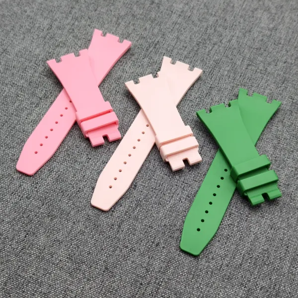 Colorful pastel silicone watch bands laid out on a gray fabric surface.