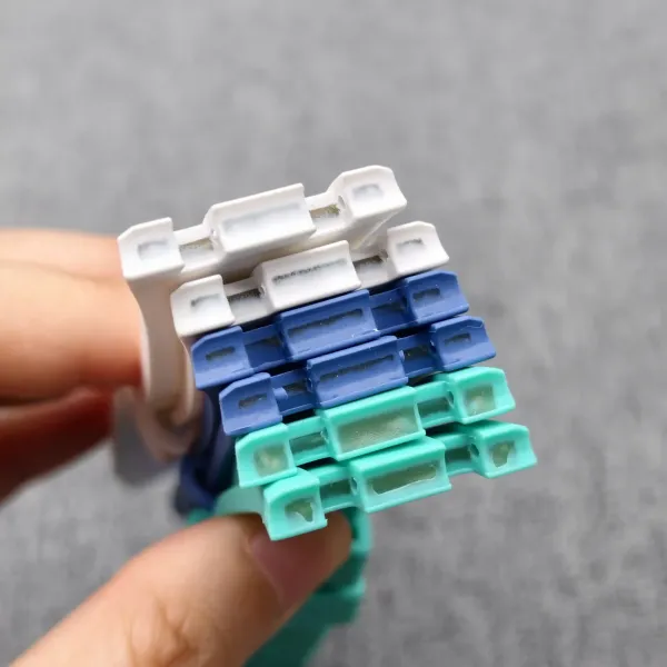 Blue and green bioceramic case parts for the AP x Swatch Royal Pop conversion kit, held in hand.