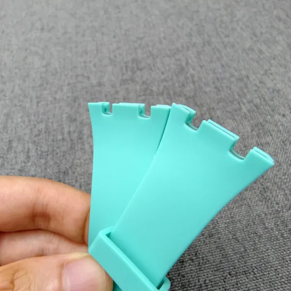 Turquoise bioceramic watch case for the AP x Swatch Royal Pop conversion kit, held between fingers.