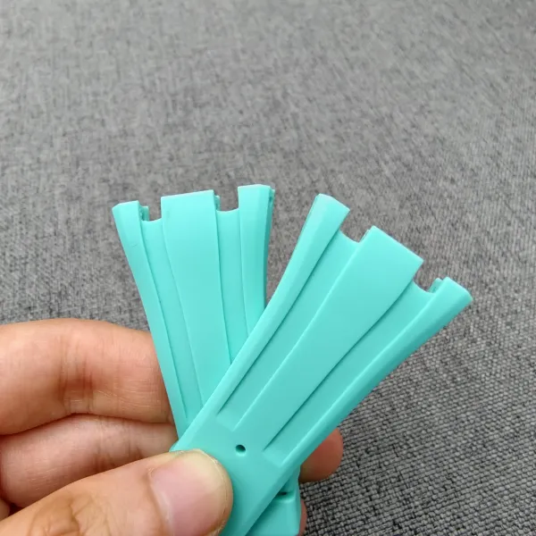 Turquoise FKM rubber strap for the AP x Swatch Royal Pop conversion kit, held in hand.