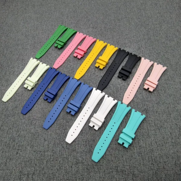 Assorted colorful silicone watch straps laid out on a gray fabric surface.